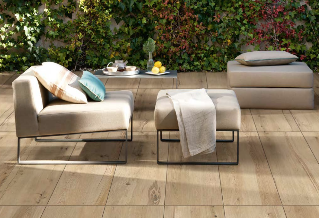 Gartenlounge-Set mit modernen Polstermöbeln und Couchtisch im Freien Ein stilvolles Gartenlounge-Set vor einer begrünten Wand mit bequemen Polstermöbeln und einem Couchtisch, auf dem Tee und Zitronen stehen.